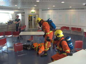 To do this, we use a heavy dummy called "Fred the Dead" and block out the masks on the gear to give the impression of smoke. Then helpful people create obstacles with chairs and tables.